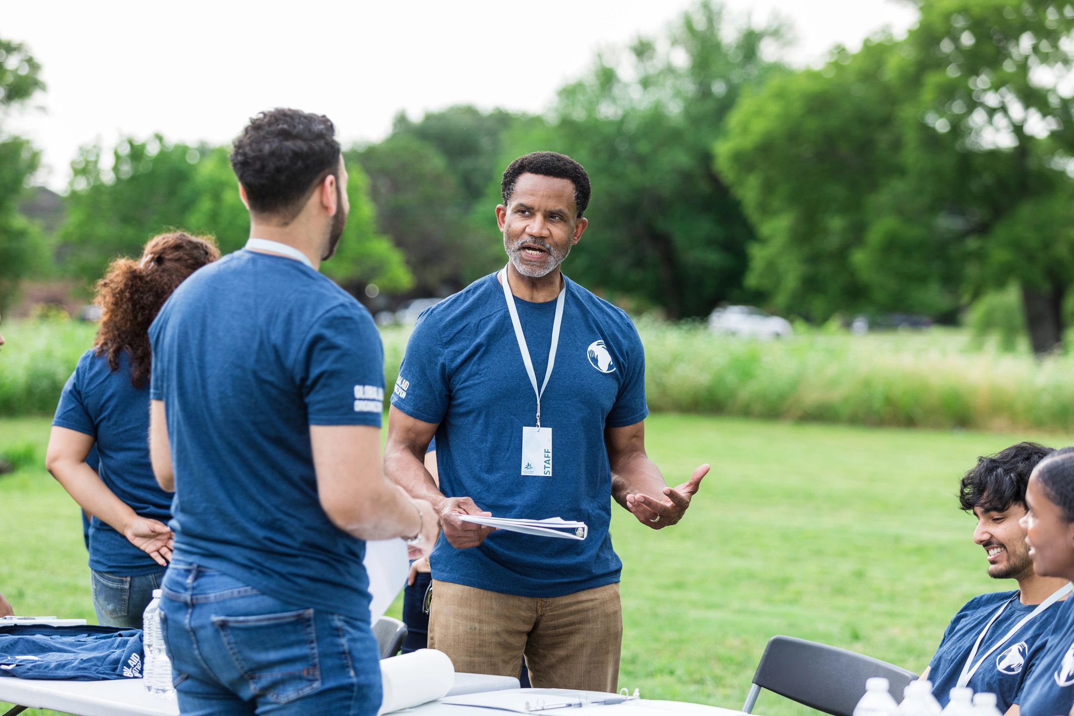 Community volunteer leader speaking with event staff at a sign-in table
