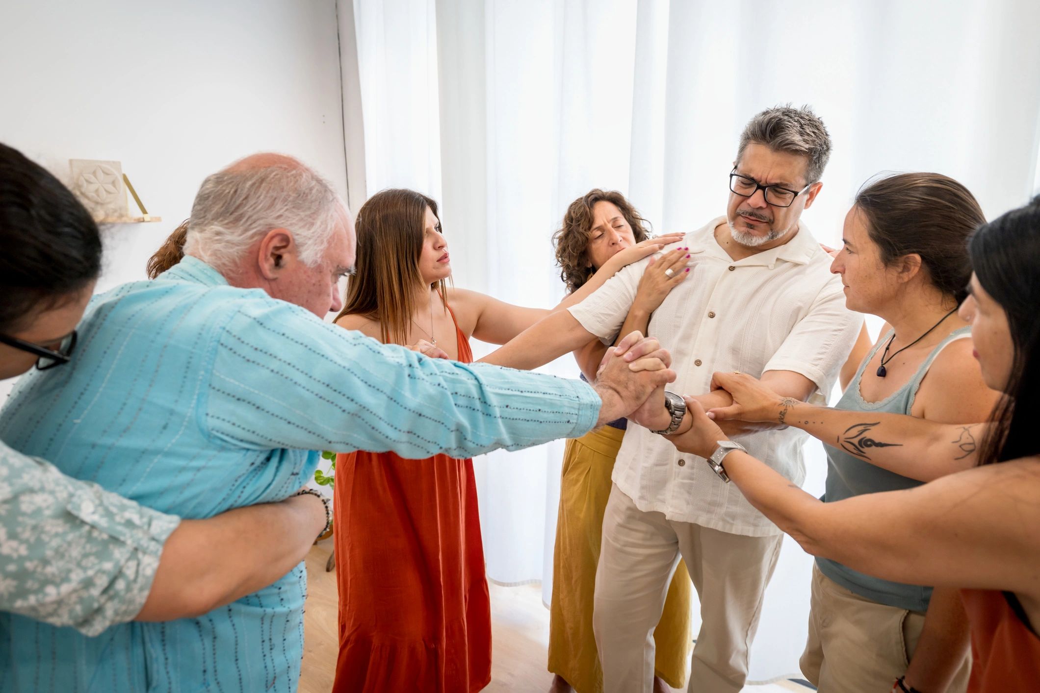 Community members standing together in a supportive circle during a wellness workshop